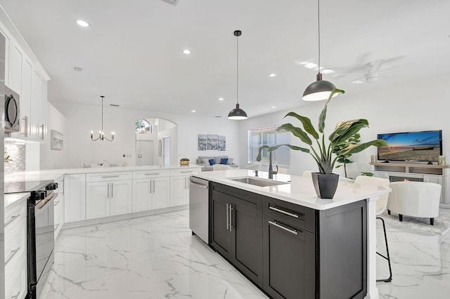 kitchen featuring decorative light fixtures, white cabinetry, sink, and appliances with stainless steel finishes