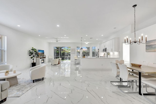 interior space featuring ceiling fan with notable chandelier