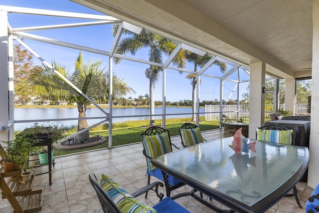 sunroom featuring a water view