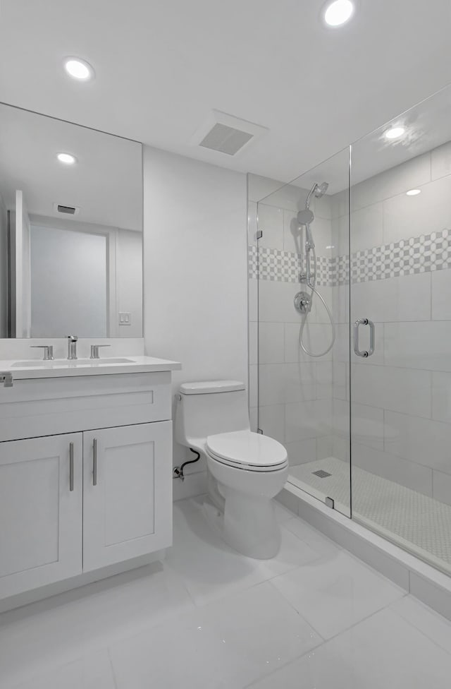 bathroom featuring tile patterned floors, a shower with door, vanity, and toilet