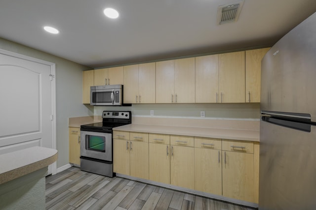 kitchen featuring light brown cabinets, light hardwood / wood-style floors, and appliances with stainless steel finishes