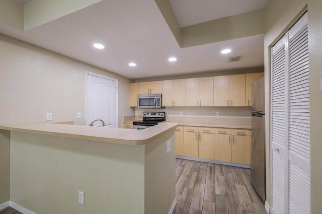 kitchen featuring kitchen peninsula, light brown cabinetry, stainless steel appliances, sink, and light hardwood / wood-style flooring