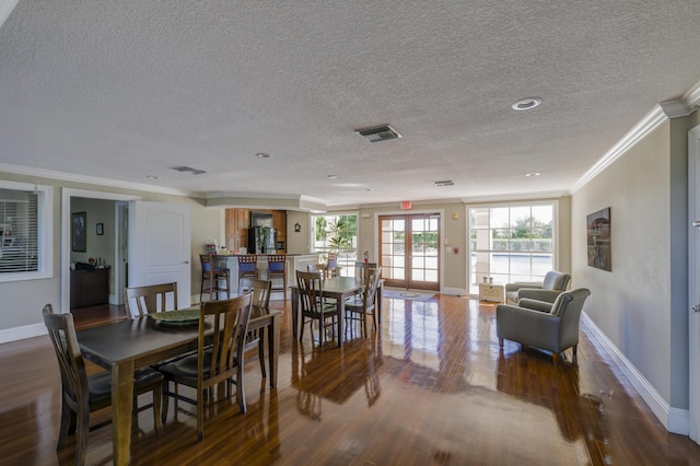 dining area featuring a textured ceiling, wood-type flooring, crown molding, and french doors