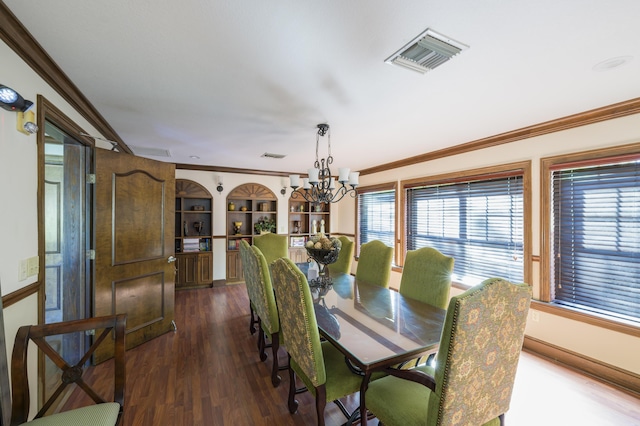 dining area featuring built in shelves, crown molding, a chandelier, and dark hardwood / wood-style floors