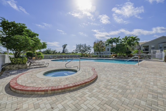 view of swimming pool featuring a community hot tub and a patio