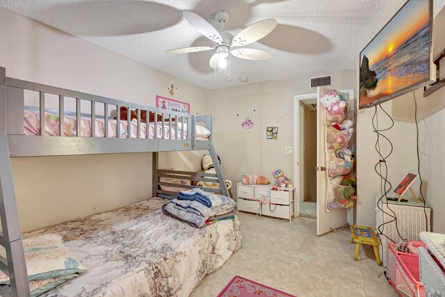 bedroom with ceiling fan and a textured ceiling