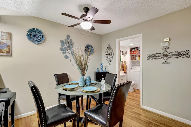 dining room featuring washer / clothes dryer, ceiling fan, light hardwood / wood-style flooring, and a textured ceiling