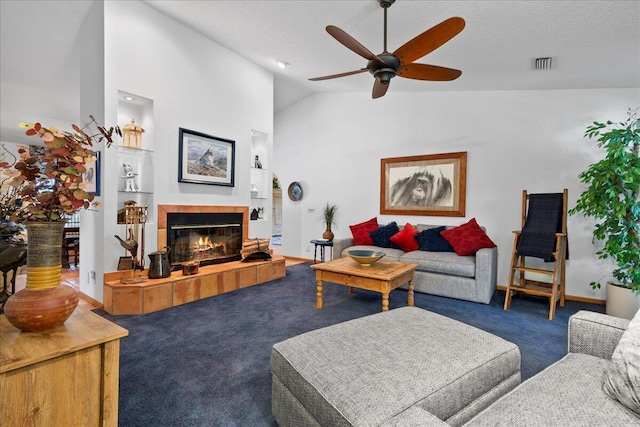 carpeted living room featuring ceiling fan, a textured ceiling, high vaulted ceiling, and a tiled fireplace