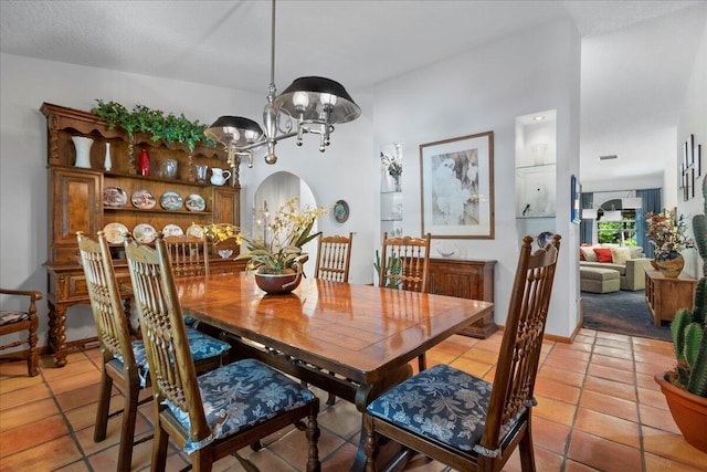 tiled dining room featuring an inviting chandelier