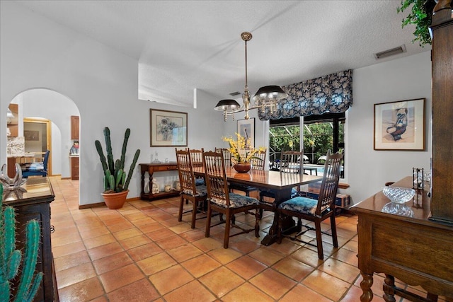 17602 Bridle Ct, Jupiter, FL 33478 - dining space with arched walkways, a chandelier, light tile patterned floors, and a textured ceiling