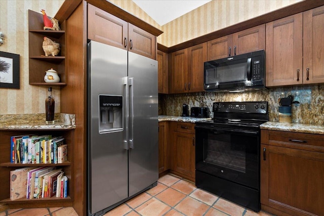 kitchen with light tile patterned floors, backsplash, light stone counters, and black appliances