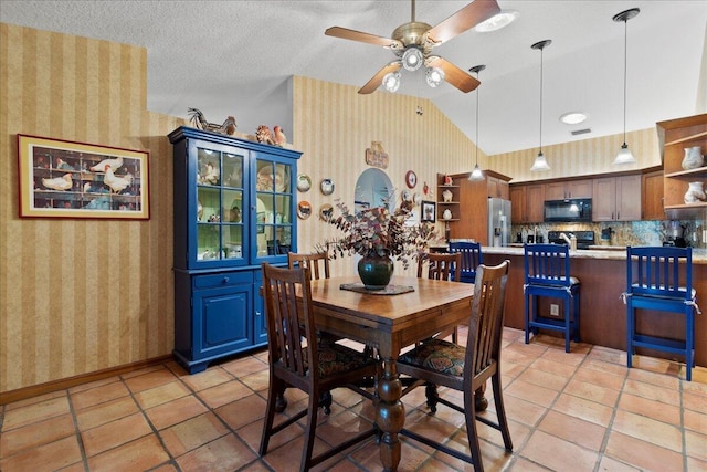 dining room with light tile patterned floors, ceiling fan, wallpapered walls, and vaulted ceiling