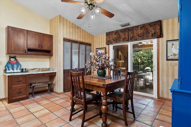 dining space featuring ceiling fan, light tile patterned floors, and a textured ceiling