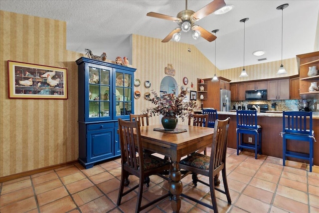 dining space featuring a textured ceiling, ceiling fan, light tile patterned flooring, and lofted ceiling