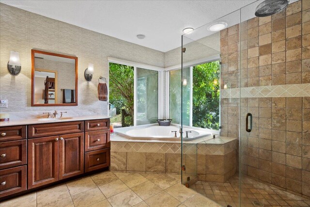 bathroom featuring tile patterned floors, vanity, a shower stall, and a bath
