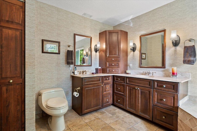 full bath featuring double vanity, toilet, tile patterned floors, and a sink
