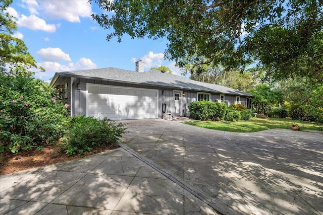 17602 Bridle Ct, Jupiter, FL 33478 - ranch-style house with driveway, an attached garage, board and batten siding, a chimney, and a front yard
