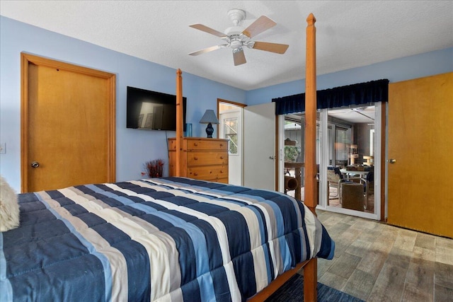 bedroom with hardwood / wood-style floors, ceiling fan, and a textured ceiling