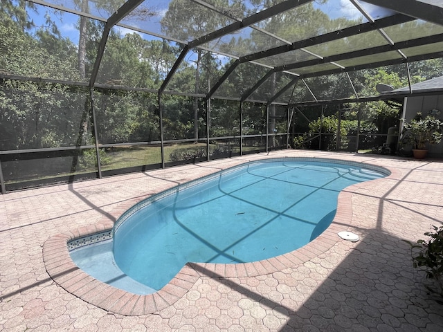 pool with glass enclosure and a patio area