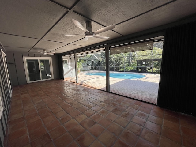 unfurnished sunroom featuring ceiling fan and a swimming pool