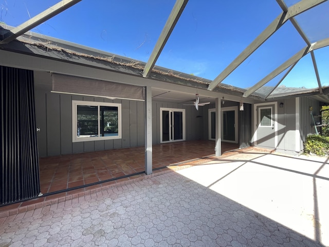 rear view of property featuring glass enclosure, a patio area, and ceiling fan