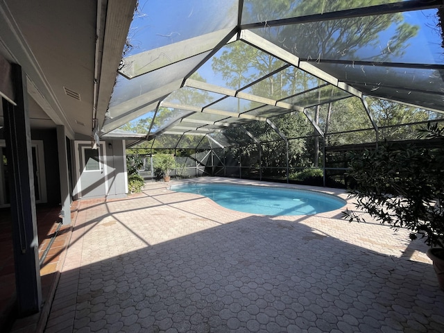 view of swimming pool featuring a patio area and a lanai