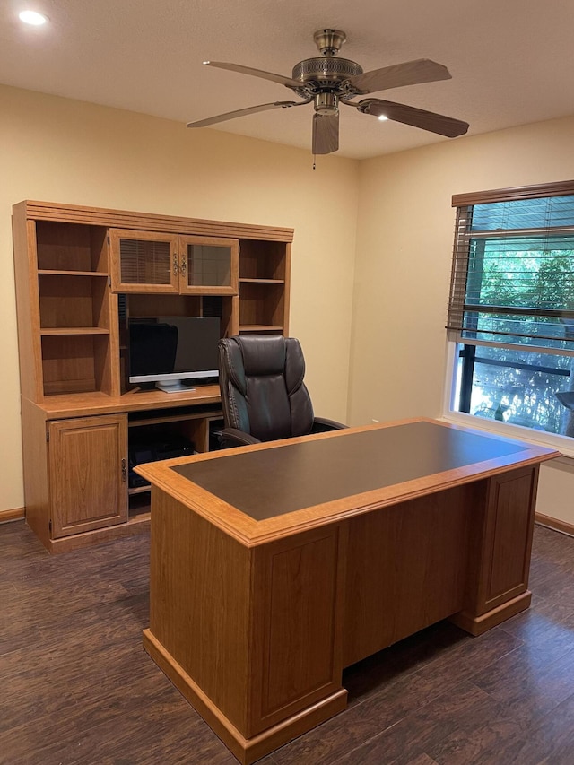 unfurnished office with ceiling fan and dark hardwood / wood-style flooring