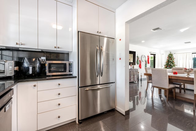 kitchen with stainless steel appliances, white cabinetry, granite finish floor, and visible vents