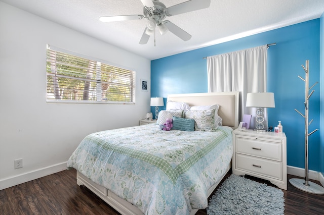 bedroom with a textured ceiling, dark wood-type flooring, and baseboards