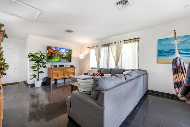 living area with attic access, visible vents, and baseboards