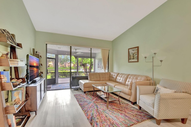 living room featuring lofted ceiling and light wood-type flooring