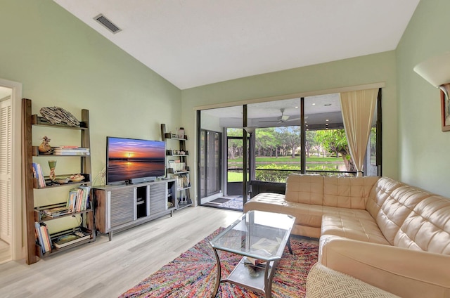 living room featuring light wood-type flooring and vaulted ceiling