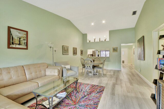 living room featuring lofted ceiling and light wood-type flooring