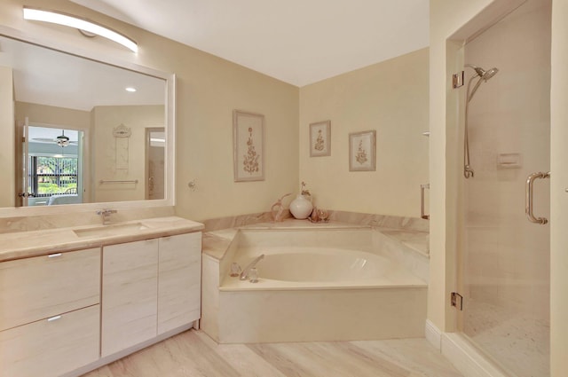 bathroom with hardwood / wood-style flooring, vanity, and plus walk in shower