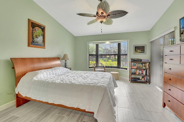 bedroom with a textured ceiling, ceiling fan, and lofted ceiling