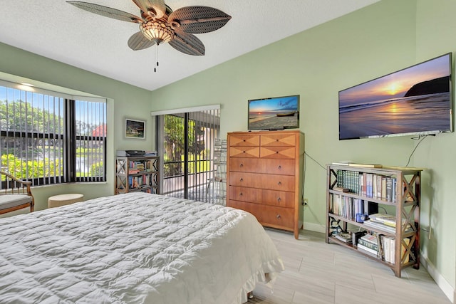 bedroom with multiple windows, ceiling fan, lofted ceiling, and access to exterior