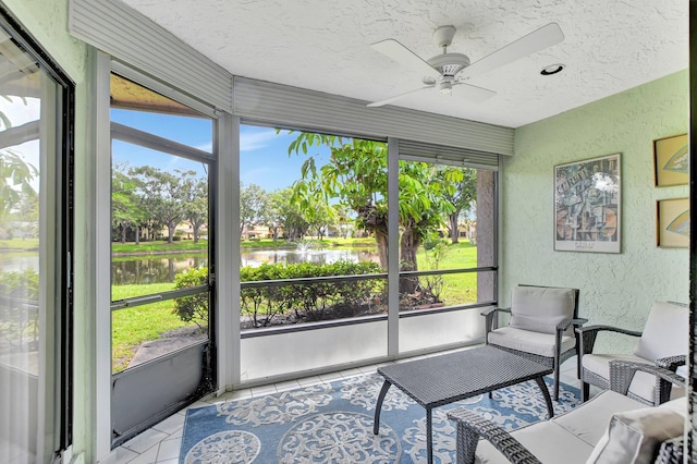 sunroom / solarium featuring plenty of natural light, ceiling fan, and a water view