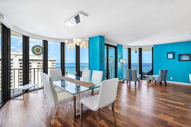 dining area with hardwood / wood-style flooring, expansive windows, and a water view