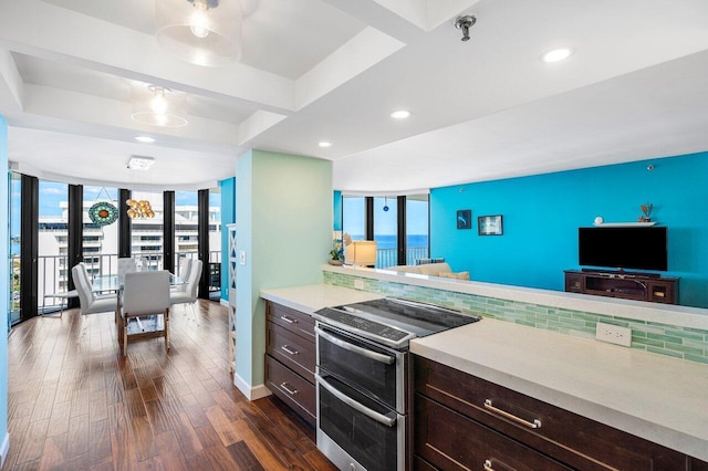 kitchen featuring dark hardwood / wood-style flooring, plenty of natural light, stainless steel electric range, and a wall of windows