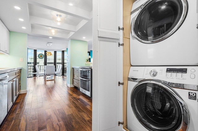 clothes washing area featuring dark hardwood / wood-style floors and stacked washer and clothes dryer