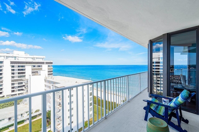 balcony featuring a water view and a view of the beach