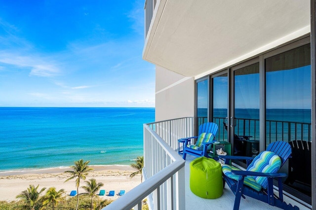 balcony featuring a view of the beach and a water view