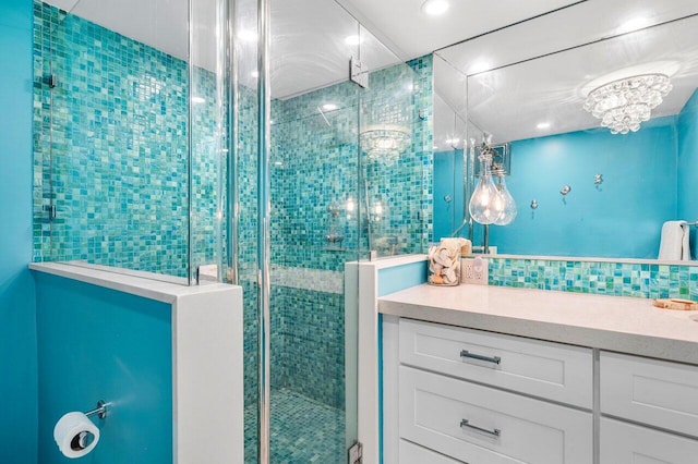 bathroom featuring tasteful backsplash, vanity, and a shower with shower door