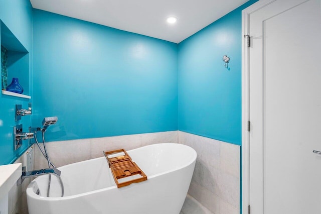 bathroom with a bathtub and tile walls