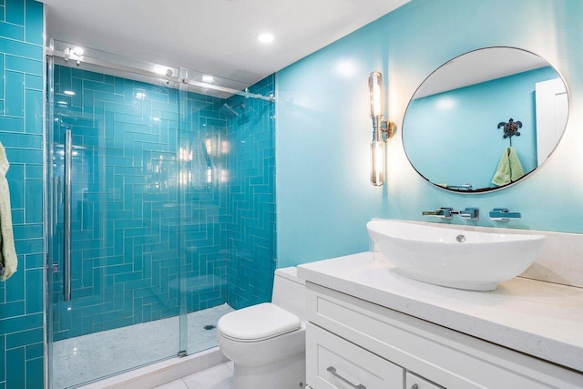 bathroom featuring tile patterned floors, a shower with door, vanity, and toilet