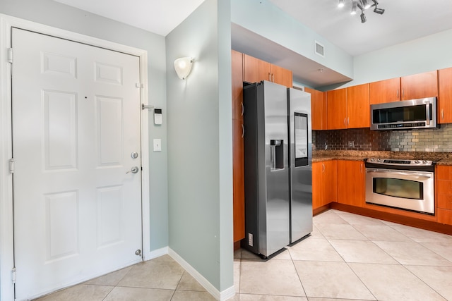 kitchen with light tile patterned floors, backsplash, and appliances with stainless steel finishes