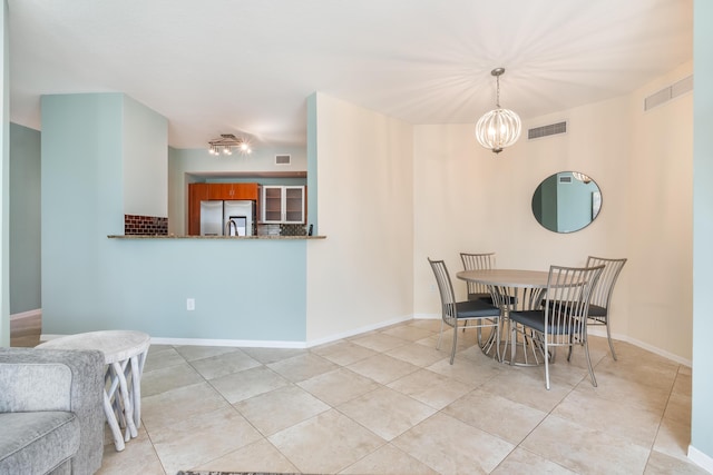 dining area with light tile patterned floors and an inviting chandelier