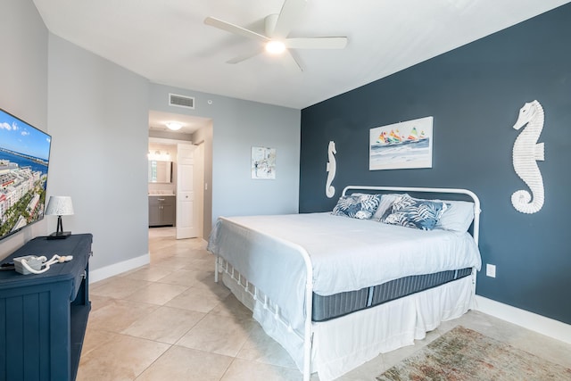 bedroom with light tile patterned floors, ensuite bath, and ceiling fan