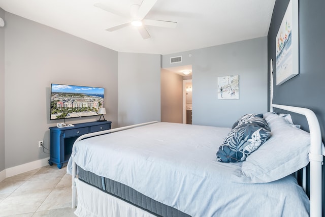 tiled bedroom featuring connected bathroom and ceiling fan