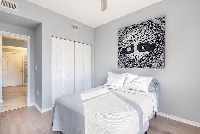 bedroom with light wood-type flooring, a closet, and ceiling fan